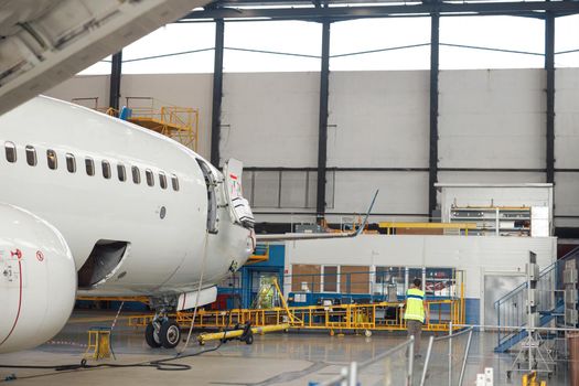 Aircraft. Passenger airplane under heavy maintenance in airport hangar indoors. Plane, shipping, transportation concept