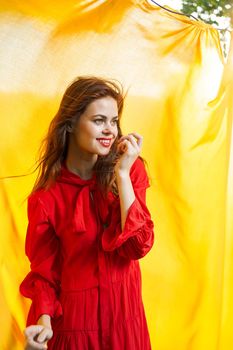 women near yellow fabric in nature in red dress fashion. High quality photo