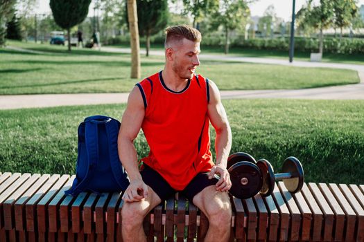 athletic man in red t-shirt in fitness park. High quality photo