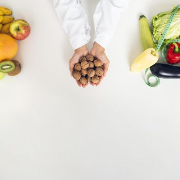 close up person with vegetables holding nuts