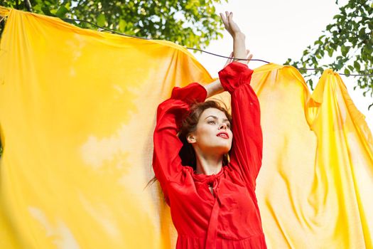 woman in red dress outdoors yellow bedspread. High quality photo