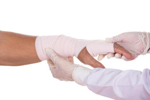 Close-up female doctor is bandaging hand of patient on white background