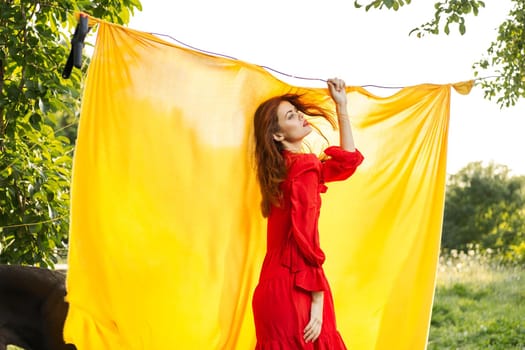 pretty woman in red dress gesturing with her hands nature yellow background. High quality photo