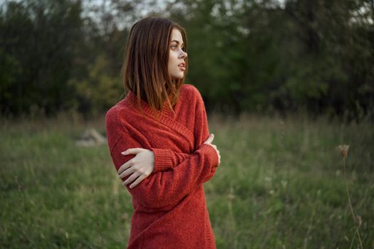 woman in a red sweater outdoors in the field nature rest. High quality photo