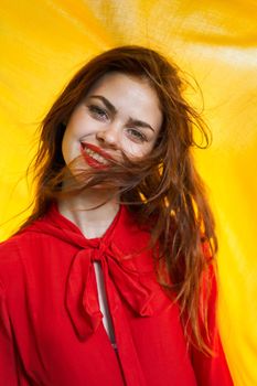 smiling woman in red dress posing yellow background. High quality photo