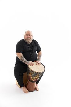 Funn caucasian bearded tattoed man is posing on white background