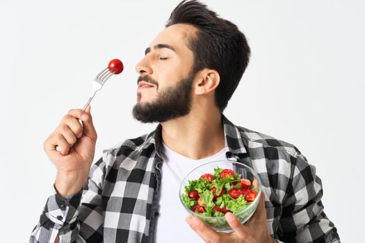 emotional bearded man in plaid shirt plate with salad. High quality photo