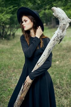 woman in black witch costume in forest nature posing. High quality photo