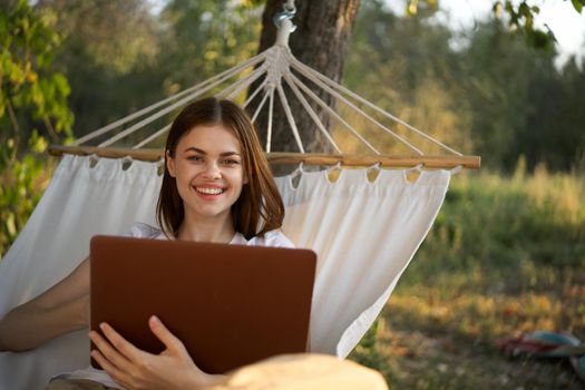 woman with laptop and lies in a hammock vacation nature freelance. High quality photo