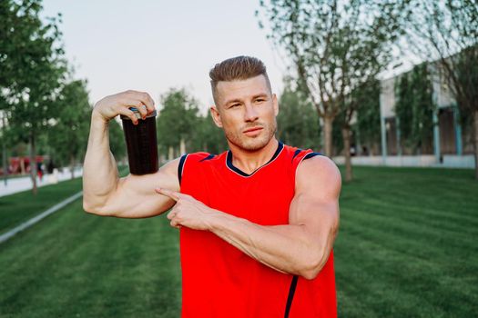 sporty man in the park outdoors glass with drink. High quality photo