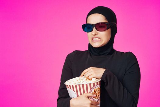 Muslim woman in 3D glasses popcorn entertainment movies model ethnicity. High quality photo