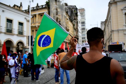 salvador, bahia, brazil - july 24, 2018: protester carries the Brazilian flag during protest against the government of President Jair Bolsonaro in the city of Salvador.