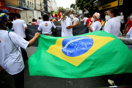 salvador, bahia, brazil - july 24, 2018: protester carries the Brazilian flag during protest against the government of President Jair Bolsonaro in the city of Salvador.