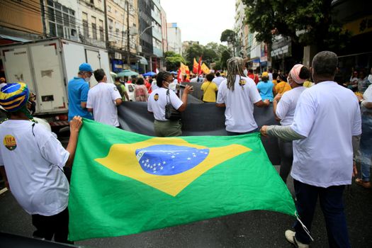 salvador, bahia, brazil - july 24, 2018: protester carries the Brazilian flag during protest against the government of President Jair Bolsonaro in the city of Salvador.