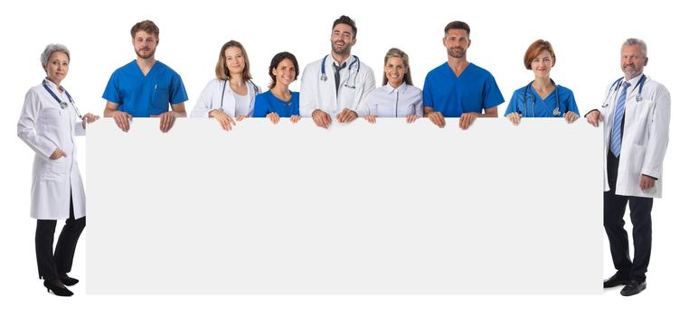 Full length portrait of confident multiethnic medical doctors team holding blank billboard isolated on white background, copy space for text