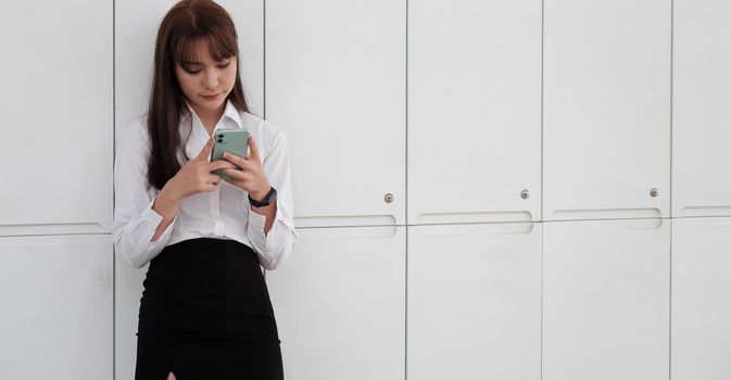 cute girl standing and using mobile phone on white background