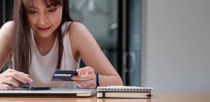 Smiling woman use mobile phone for shopping online with credit card.