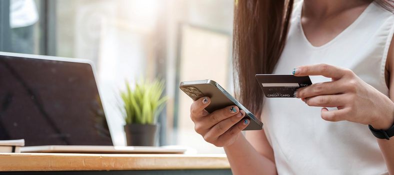 Pay for goods by credit card through a smartphone in a coffee shop..