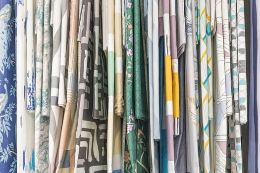 multicolored textures of fabrics on the shelves of stores close-up. High quality photo