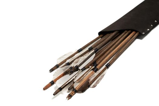 Closeup view of ancient wooden arrows with grey feathers isolated on white background. Qualitative old medieval weapon in black leather case.