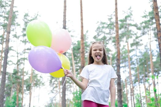 pretty preschool girl having fun playing with hot air balloons outdoors. hollidays, party, birthday, celebration. happy children.