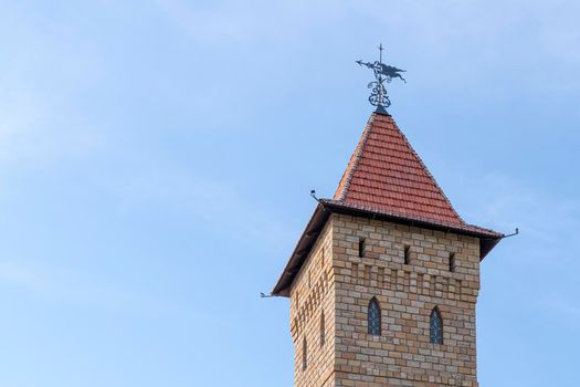 the tower of an old castle with a weather vane. High quality photo