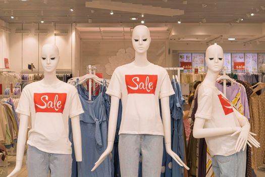 mannequins in a store with the word sale on clothes. High quality photo