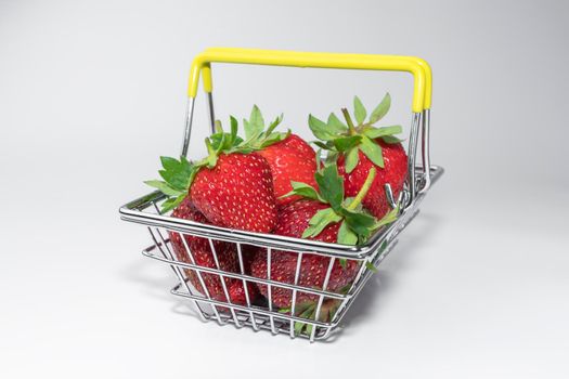 strawberries in a supermarket basket close-up on a white background. High quality photo