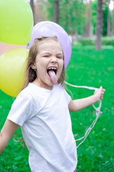 pretty preschool girl having fun playing with hot air balloons outdoors. hollidays, party, birthday, celebration. happy children.