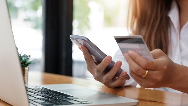 Online payment woman's hands holding smartphone and using credit card for online shopping. Cyber Monday Concept.