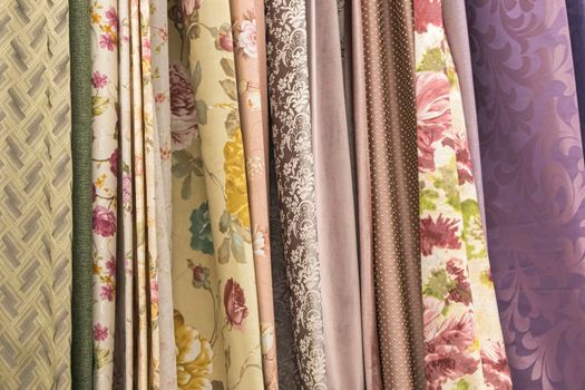 multicolored textures of fabrics on the shelves of stores close-up. High quality photo