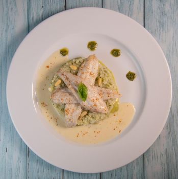 Baked sole fillet, risotto and pesto recipe. High quality photo