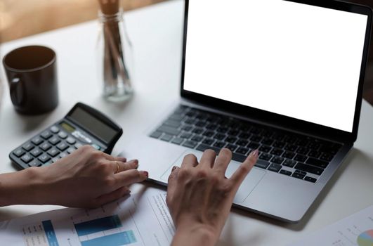 women using laptop computer working at home with blank white desktop screen..