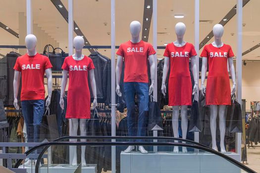 mannequins in a store with the word sale on clothes. High quality photo