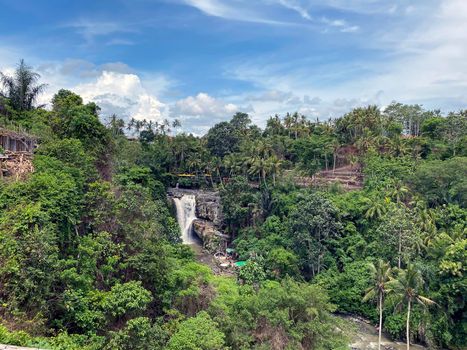 Waterfall flowing over rocky river in jungle, Bali, Indonesia - stock photo