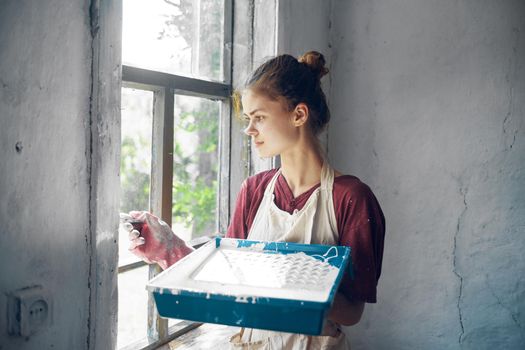 woman in apron painter repair painting window. High quality photo