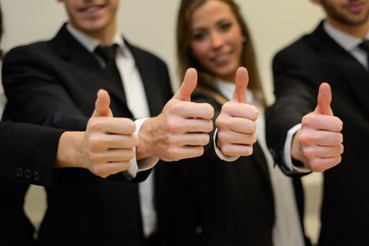 Close-up of business team holding their thumbs up