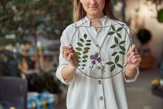 Young female caucasian woman florist is holding her work