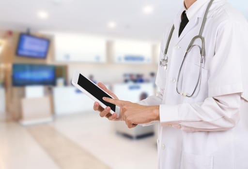 Doctor working on a digital tablet in hospital background