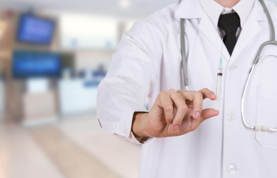 doctor holding syringe in hospital background