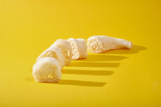 cut dried loofah on yellow background, zero waste lifestyle concept