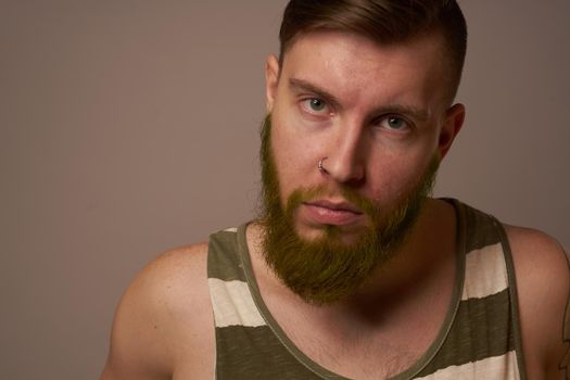 bearded man in striped t-shirt with tattoos posing studio. High quality photo