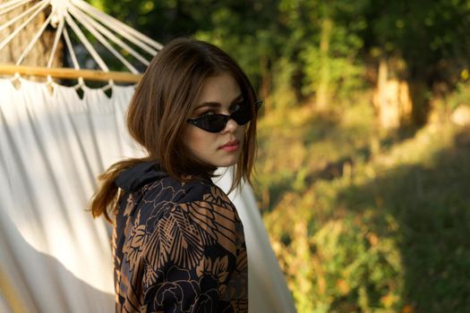 woman in sunglasses lies in a hammock outdoors summer lifestyle. High quality photo