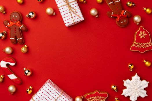 New Year background with festive decorations and gingerbread cookies on red
