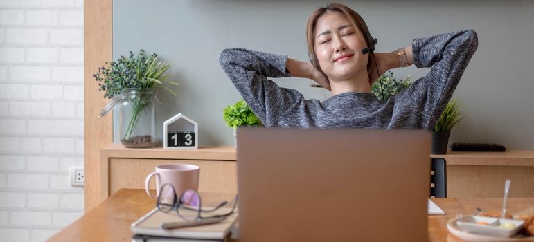 Cropped shot smiling asian woman freelancer wearing headset, communicating with client via video computer call. Millennial pleasant professional female tutor giving online language class.