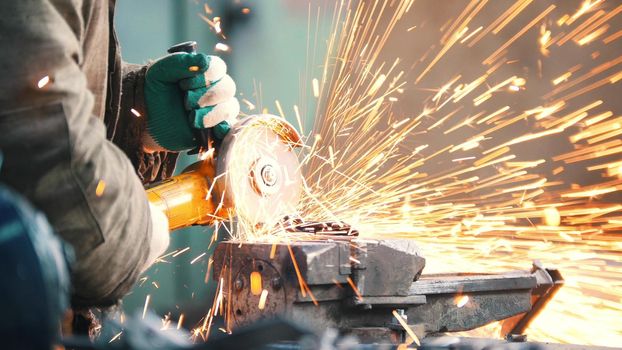 Industrial. Construction site. The man worker grinding. Fire sparkles. Mid shot