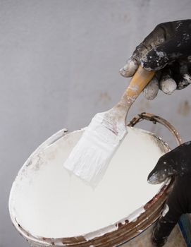 white paint brush with the paint tin 