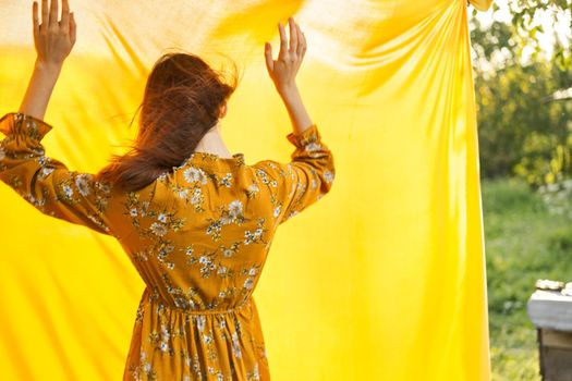 woman in dress posing nature yellow cloth fresh air. High quality photo