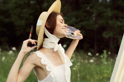 cheerful woman in a dress outdoors painting a picture art creative. High quality photo