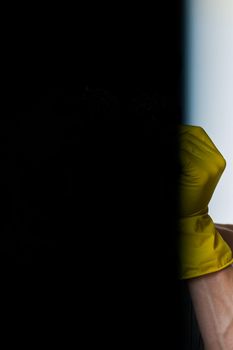 a man in a gray apron wearing rubber gloves cleaning washing. High quality photo